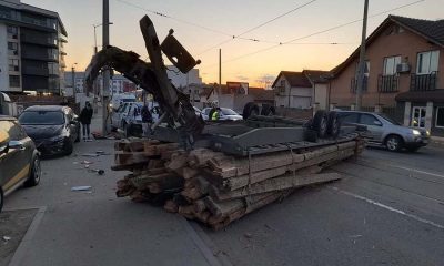 ACCIDENT în Cluj-Napoca: O remorcă plină cu lemne a ajuns cu roțile în sus lovind şi un stâlp de electricitate