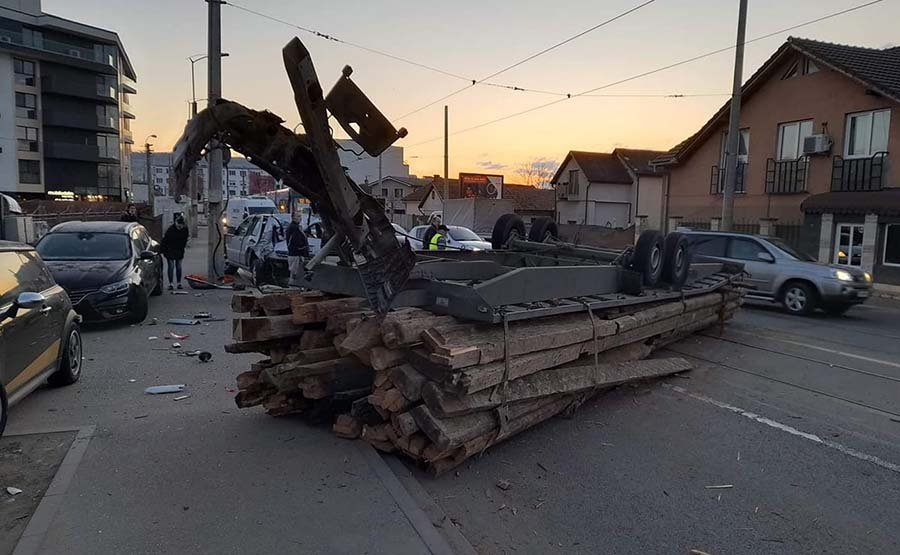 ACCIDENT în Cluj-Napoca: O remorcă plină cu lemne a ajuns cu roțile în sus lovind şi un stâlp de electricitate