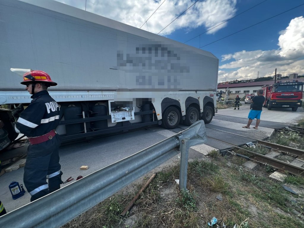 Un TIR a rămas blocat peste calea ferată în Baciu. Traficul feroviar a fost oprit