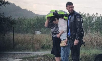 IMAGINEA ZILEI vine de la Cluj: Un polițist și-a oferit haina unor femei pentru a le feri de ploaie